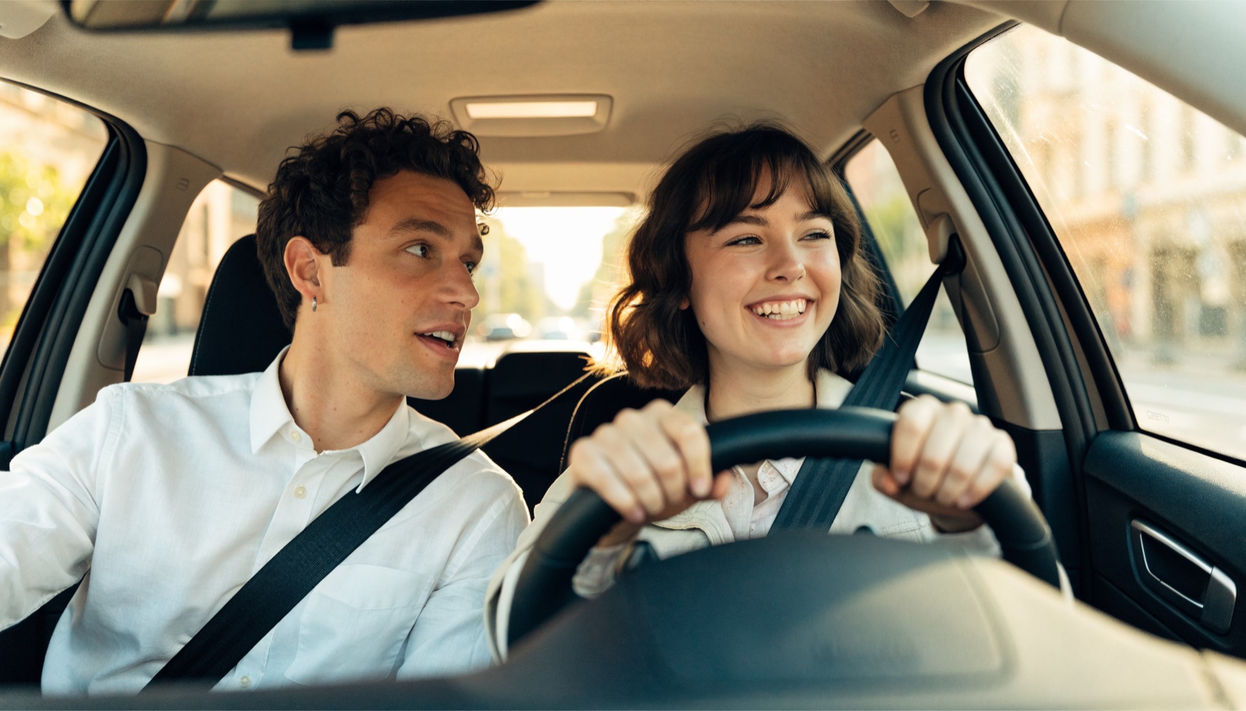 Nova Skills driving instructor coaching a smiling learner driver behind the wheel